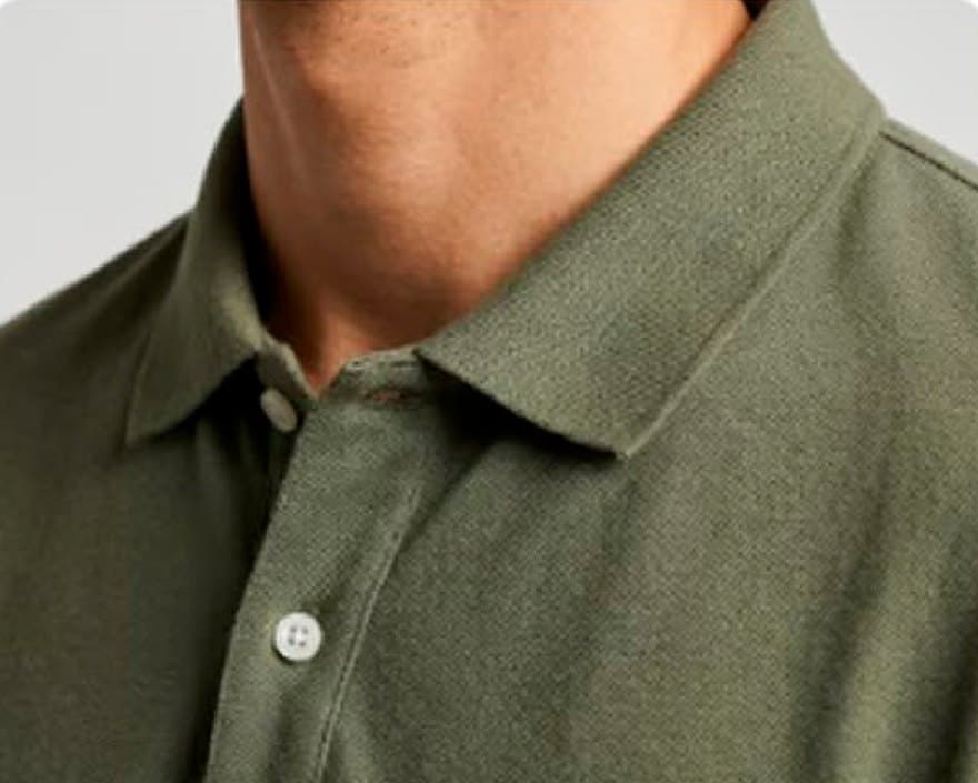 Close na gola e nos botões da camisa polo verde